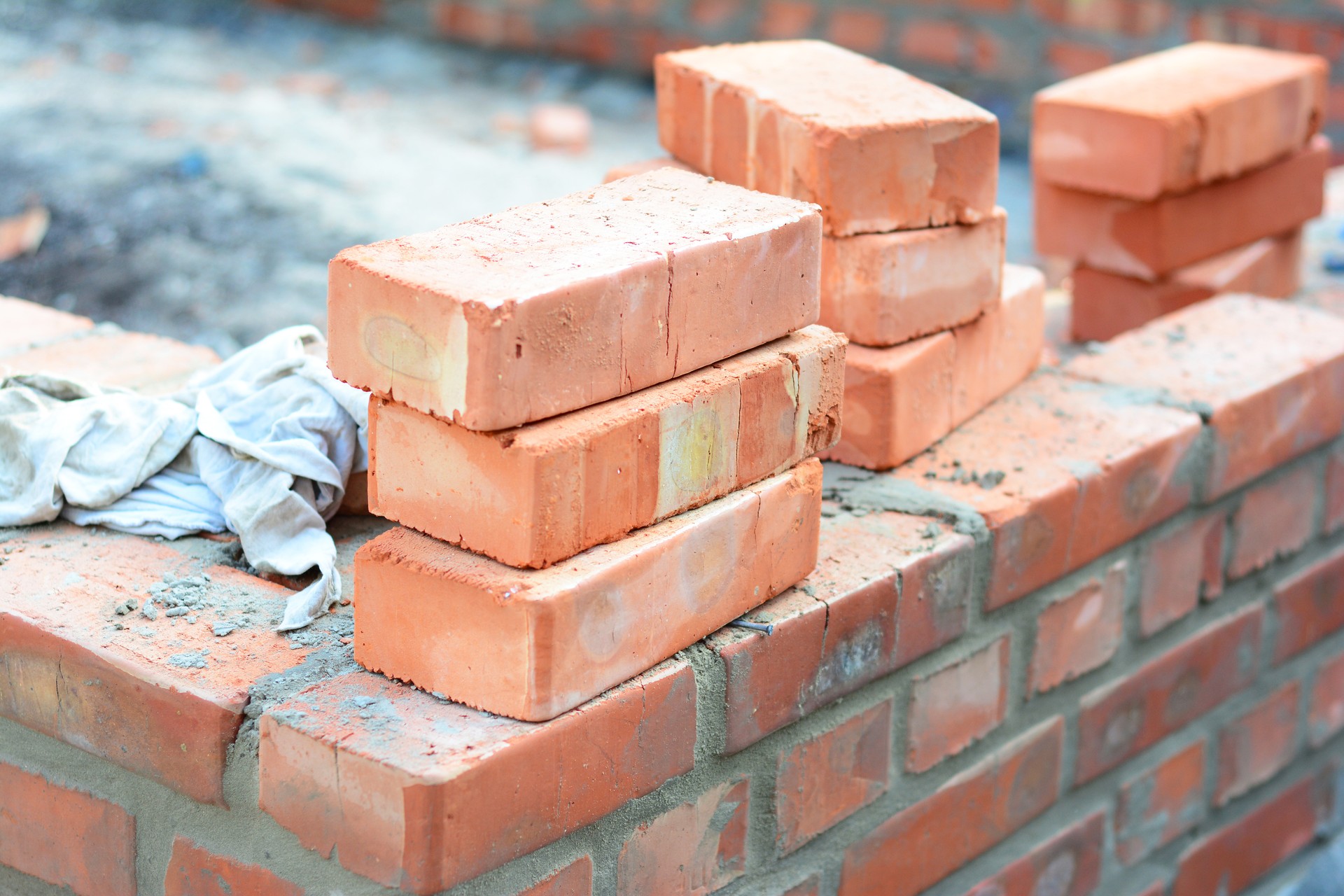 Brick house wall constuction with stack of red bricks. Building house brick wall concept.